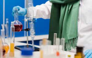 Laboratory technician conducting chemical testing using glass laboratory equipment and chemical solutions.