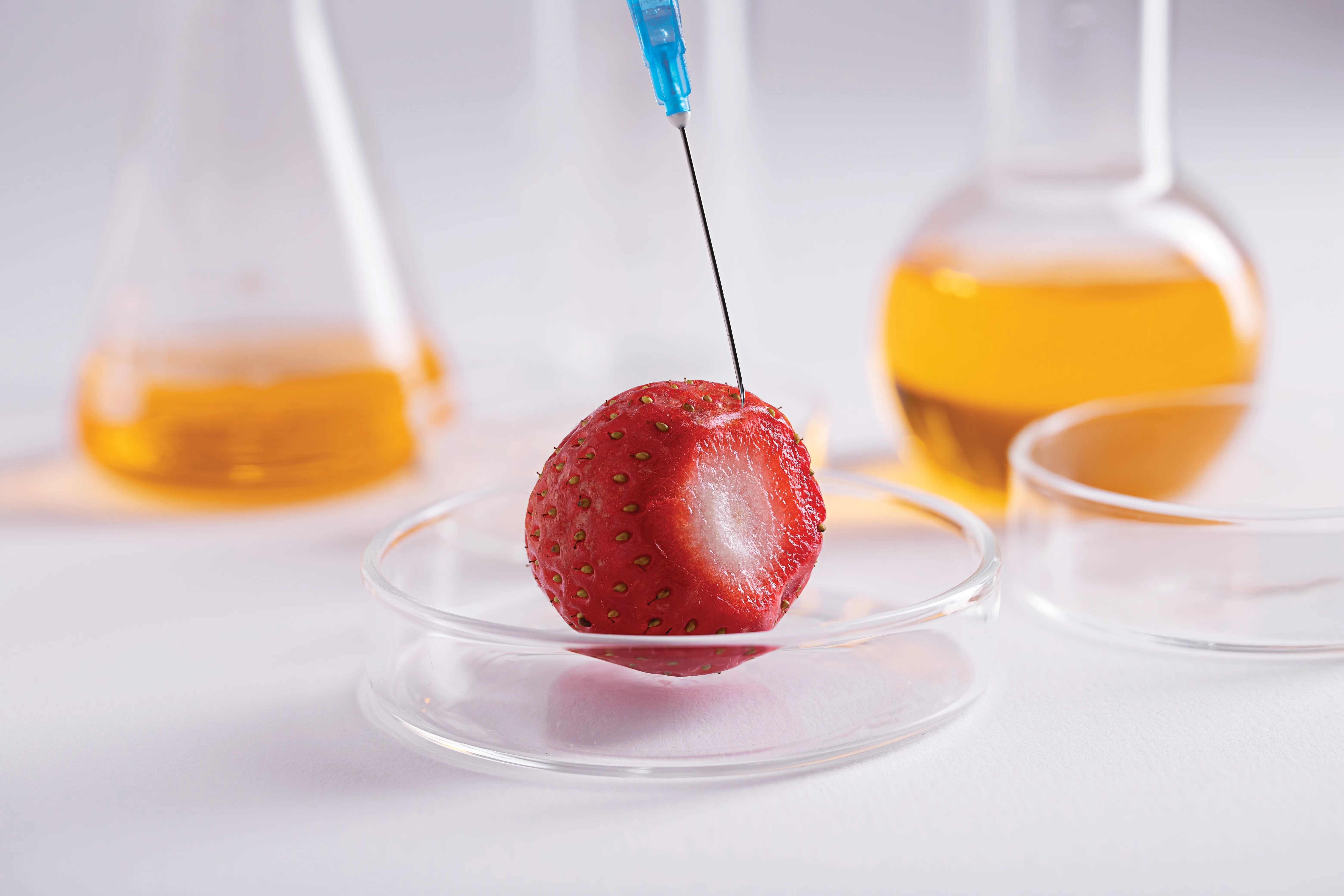 gloved hand holding test tube by river