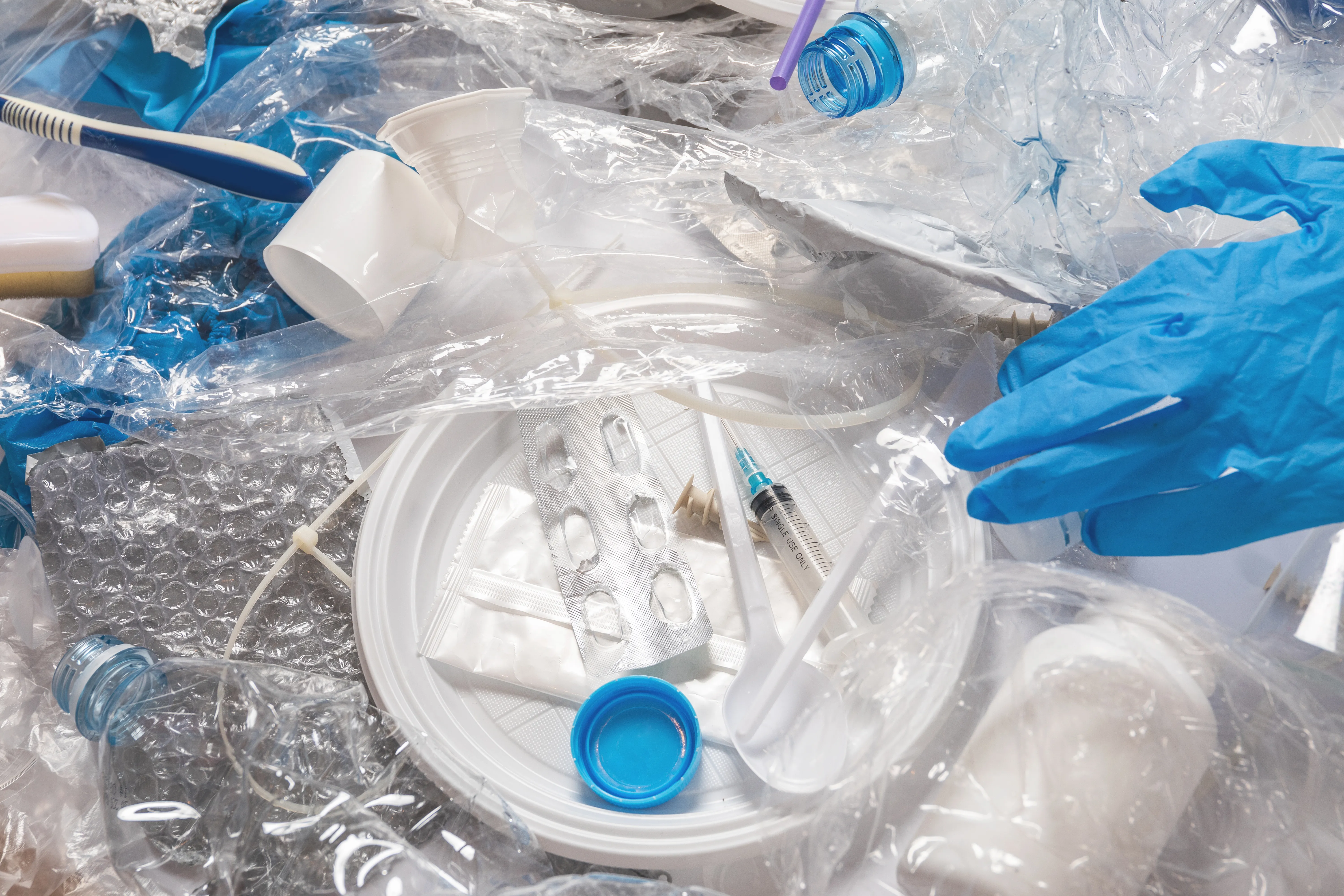 gloved hand holding test tube by river