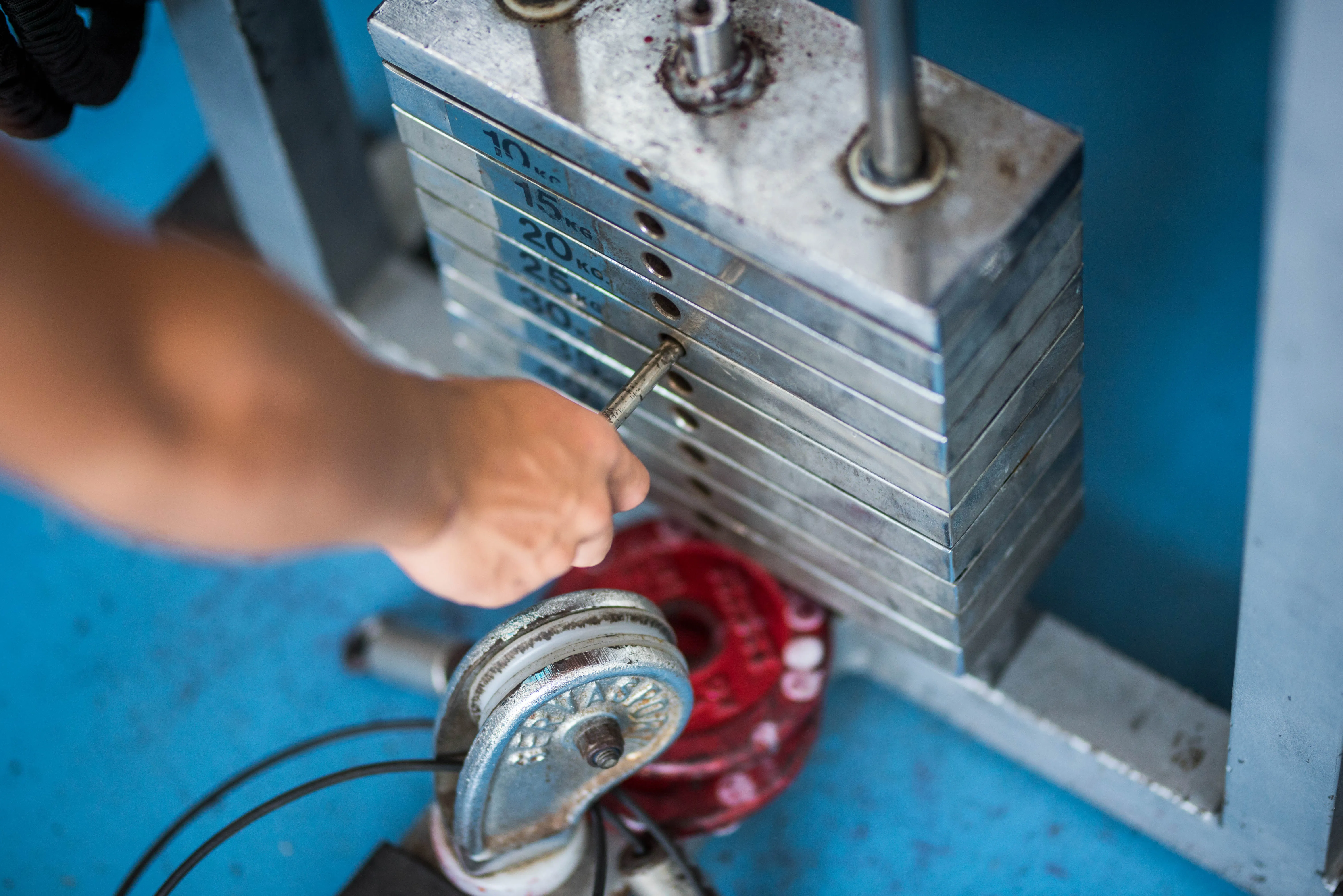 gloved hand holding test tube by river