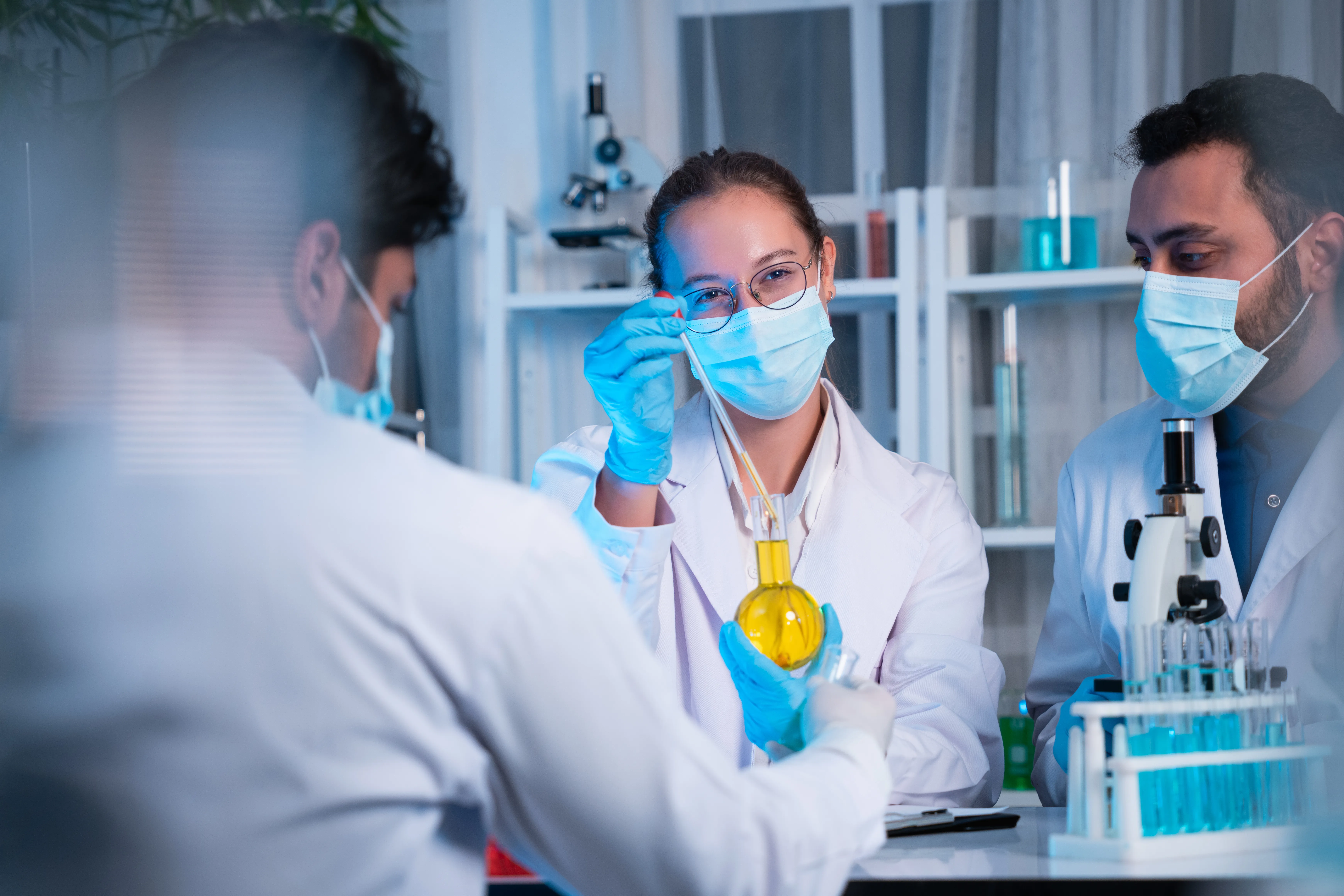 gloved hand holding test tube by river